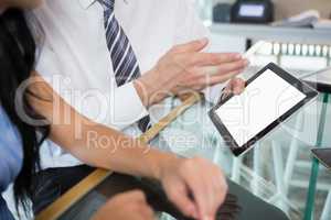 Businessman discussing with colleague over digital tablet