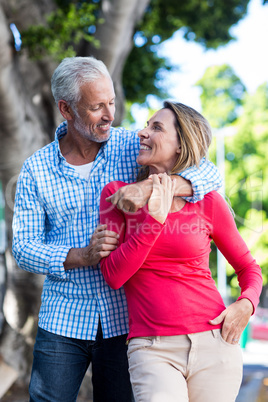 Romantic mature couple standing against tree
