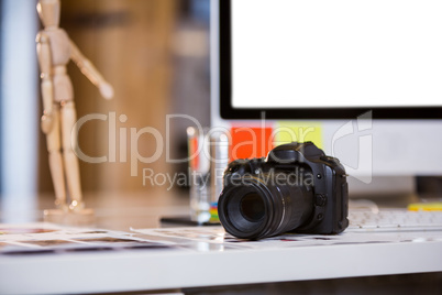 Camera on photographs at computer desk