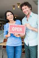 Couple holding open signboard