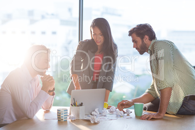 Creative colleagues discussing at desk