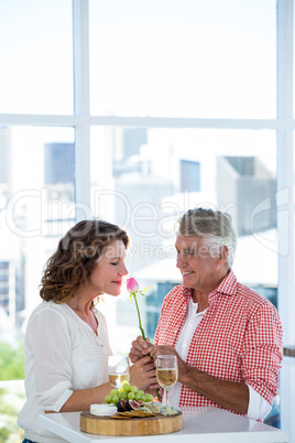 Woman with man smelling flower