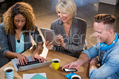 Creative business people using technologies at table