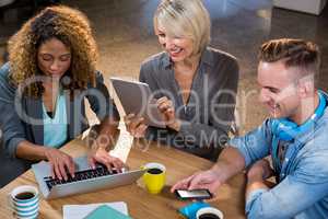 Creative business people using technologies at table