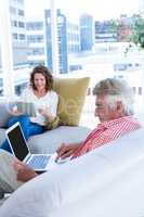 Mature man with notebook while sitting by woman