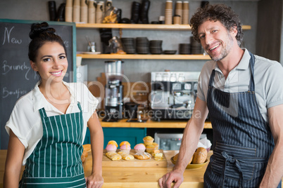 Waiter and waitress standing at counter in cafeteria