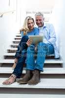 Full length of couple using digital tablet