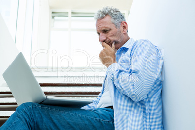 Focused man using digital tablet on steps