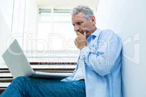 Focused man using digital tablet on steps