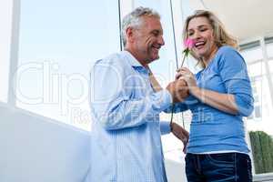 Happy man giving rose to woman