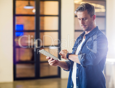 Man checking time while holding tablet in office