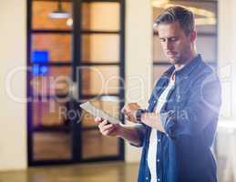 Man checking time while holding tablet in office