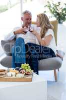 Couple toasting red wine with food