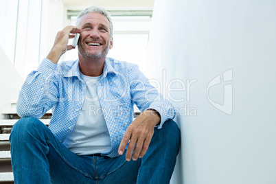 Mature man using mobile phone on steps