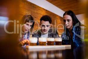 Friends looking at beer glasses on table