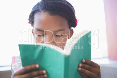 Schoolgirl reading book in library