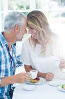 Romantic couple holding coffee cup in restaurant