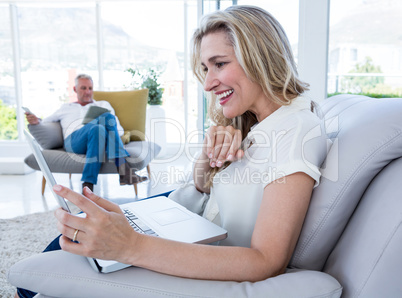 Cheerful woman with laptop and man using technology