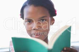 Schoolgirl reading book in library