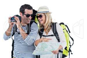 Couple with camera and map carrying luggage