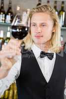 Waiter looking at a glass of wine