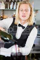 Waiter pouring wine into glass