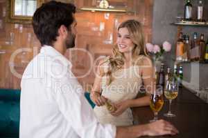 Couple standing with glass of wine in front of bar counter