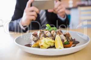 Man taking photograph of meal