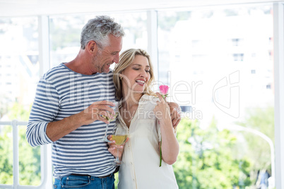Romantic mature couple with wine glasses and rose