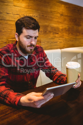 Man using digital tablet at table in restaurant