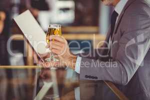 Businessman holding glass of beer and looking at menu