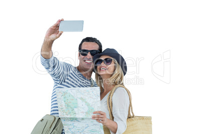 Happy couple with map taking selfie