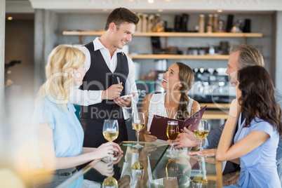 Waiter taking the order from a businessman and his colleagues