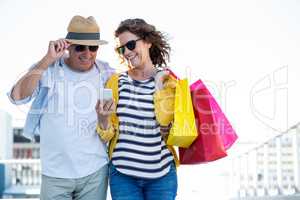 Couple with sunglasses using mobile phone