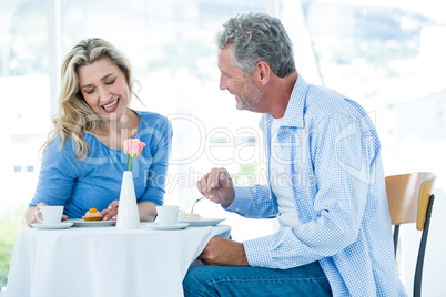 Smiling mature man looking at woman while sitting