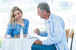 Smiling mature man looking at woman while sitting