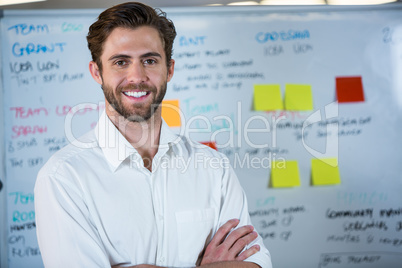 Smiling businessman against whiteboard