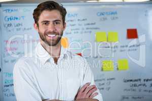 Smiling businessman against whiteboard