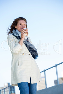 Woman drinking coffee against clear sky