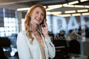 Businesswoman talking on cellphone in office