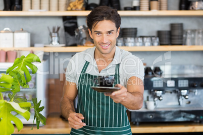 Portrait of waiter offering a cup of coffee