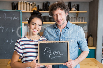 Couple holding open signboard