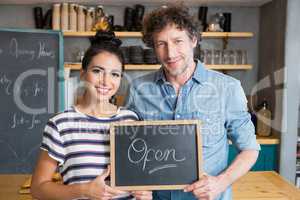 Couple holding open signboard