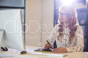 Businesswoman using graphics tablet in office