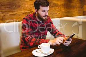 Man using mobile phone at table in restaurant