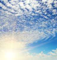 sun on blue sky with white clouds