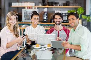 Group of friends using mobile phone, digital tablet and laptop