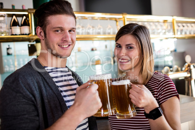 Portrait of couple toasting beer mug