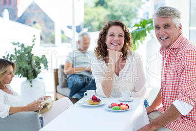 Mature couple smiling while sitting in restaurant