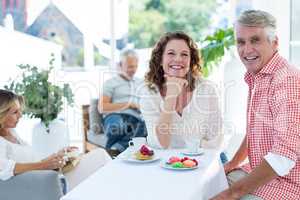 Mature couple smiling while sitting in restaurant